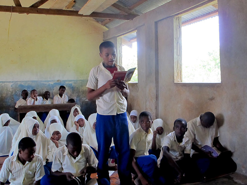A pupil at Kilindi Nungwi Primary School in Unguja reads aloud to his class. (Photo by Ashleigh Brown of Book Aid International)